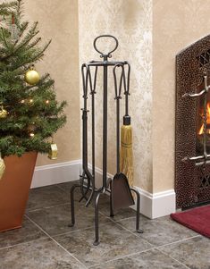 a fireplace with a potted christmas tree in front of it and a broom on the floor