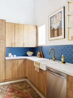 a kitchen with wooden cabinets and blue backsplash tiles on the wall above the sink