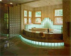 a bath room with a tub a sink and two large windows in it's walls