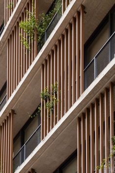 an apartment building with wooden balconies and plants growing on the balconies