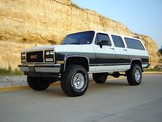 a black and white truck parked in front of a cliff