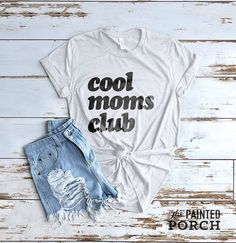 a t - shirt that says cool moms club on the front and back with ripped shorts