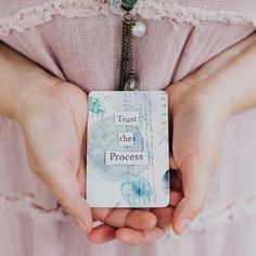 a close up of a person holding an object in their hands with the words trust the process written on it