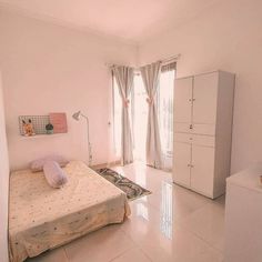 a bed room with a neatly made bed next to a white dresser and a window