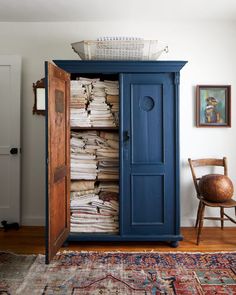 a blue armoire with lots of papers in it