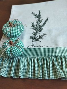 a green and white gingham ruffled table runner with pine needles on it