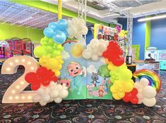 an open book sitting on top of a carpet covered floor next to balloons in the shape of numbers