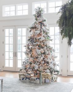 a white christmas tree with presents under it