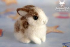 a small stuffed animal sitting on top of a blue table cloth with stars around it