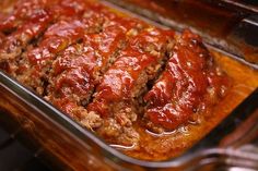 meatloaf in a glass casserole dish with sauce on top and slices cut out