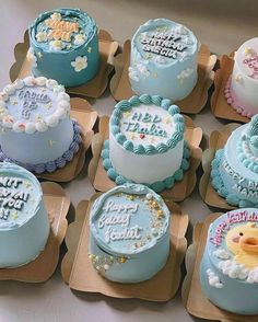 a bunch of cakes that are sitting on some trays with frosting and decorations