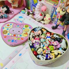 there is a bowl full of small toys on the table next to other figurines