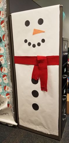 a snowman made out of paper with a red scarf on it