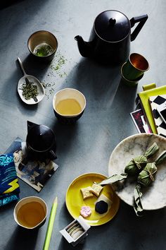 a table topped with plates and cups filled with tea