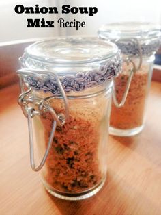 three jars filled with spices sitting on top of a wooden table