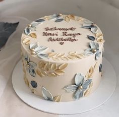 a white cake with blue and yellow flowers on it