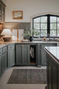 a large kitchen with gray cabinets and marble counter tops