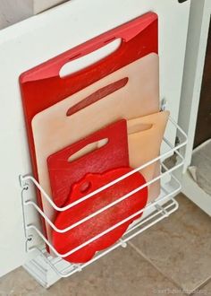 a metal rack holding cutting boards and folders in the corner of a kitchen door