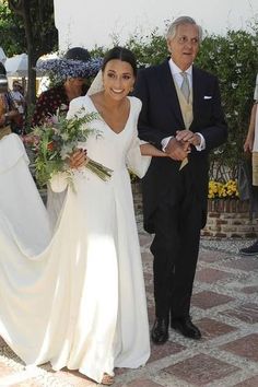 the bride and groom are walking down the street