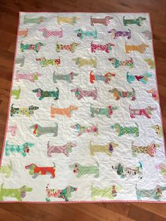 a white quilt with colorful dogs on it