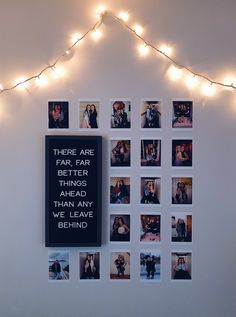 there are many pictures on the wall with lights around them and some string lights above it