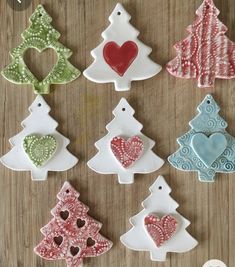 decorated christmas trees are displayed on a wooden table