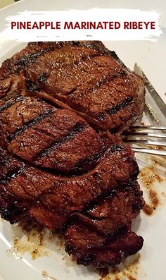 there is a piece of steak on the plate with a fork and knife next to it