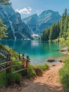 a path leading to a lake with mountains in the background