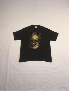 "vintage 1990s t-shirt total cotton, shrinkage controlled Lee made in USA black w/gold/blue/purple,yellow sun/moon print good vintage condition, light wear/discoloration below print(see photos) labeled size L, see below measures, lying flat, shoulder-20\" sleeve-8\" chest-21 1/2\" length-28 1/2\"     We do not offer returns or refunds unless something is grossly misrepresented. Please contact us within 2 business days of receiving to discuss any possible returns for this reason. We do not offer refunds for your shipping fees. Please feel free to contact us with any questions you may have about an item prior to purchase and we will gladly answer them." Bohemian Short Sleeve T-shirt With Sun And Moon Design, Bohemian Short Sleeve T-shirt For Streetwear, Bohemian Cotton T-shirt With Sun And Moon Design, Celestial Cotton T-shirt With Crew Neck, Vintage Gold Top With Graphic Print, Vintage Gold Tops With Graphic Print, Gold Vintage Tops With Graphic Print, Celestial Short Sleeve Cotton Tops, Celestial Style Cotton Tops With Short Sleeves