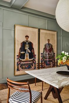 a dining room with two paintings on the wall