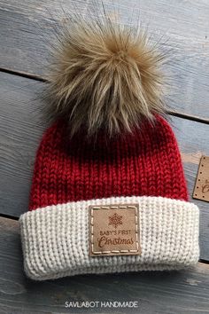 a red and white knitted hat with a fur pom