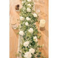 a long table with white flowers and greenery