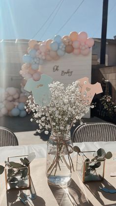 a vase filled with baby's breath flowers on top of a white table cloth