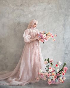 a woman in a pink dress holding flowers