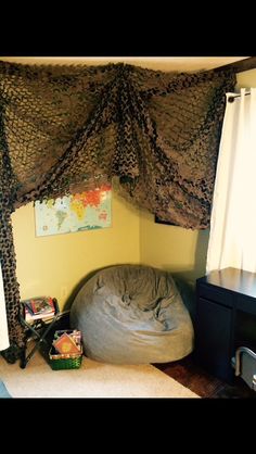 a bedroom with a bean bag chair under the canopy and curtains on the window sill