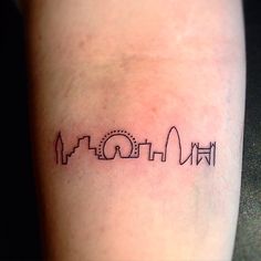 a small city skyline tattoo on the leg