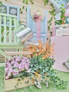 a garden filled with lots of flowers next to a wooden chair and potted plant