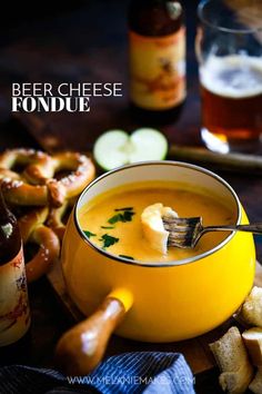 a bowl of beer cheese fondue next to pretzels