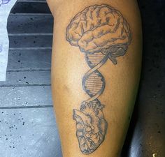 a person with a tattoo on their leg that has a drawing of a human brain and a double strand of medical equipment