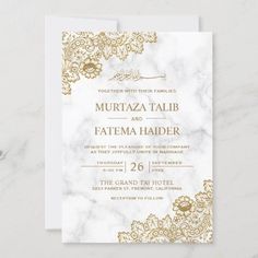 a white and gold wedding card with an ornate design on the front, in marble