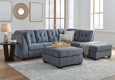 a living room with a blue couch and ottoman