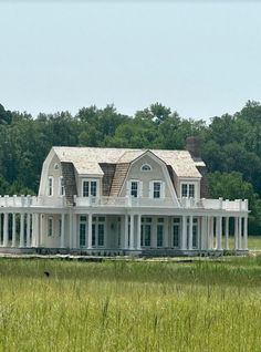 a large white house sitting on top of a lush green field