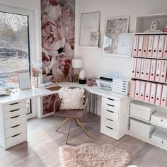 a white desk topped with lots of drawers next to a wall covered in pink flowers