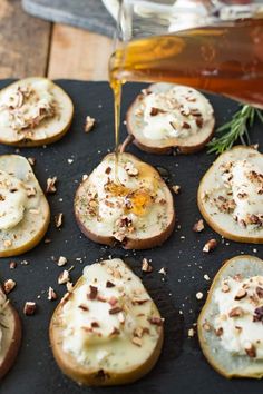 an image of baked potatoes being drizzled with honey and nuts on a baking sheet