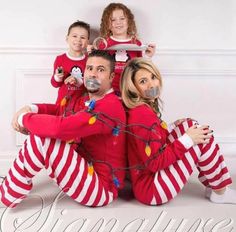 a man and two children in matching christmas pajamas are posing for a photo with santa clause on