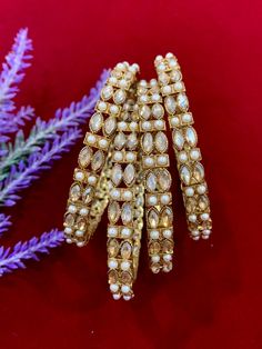 Polki bangles with pearl details. Comes in a set of 4. Traditional Pearl Bangle Bracelet, Pearl Bangle For Wedding, Elegant Festive Pearl Bangle Bracelet, Elegant Festive Pearl Bracelets, Festive Pearl Bangle Jewelry, Festive Pearl Bracelets For Wedding, Polki Bangles, Pearl Details, Bangles