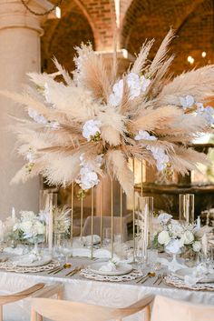 an elegant table setting with tall centerpieces and white flowers