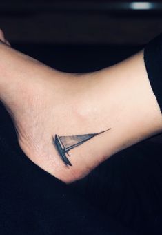 a person with a tattoo on their foot has a knife in the shape of a triangle