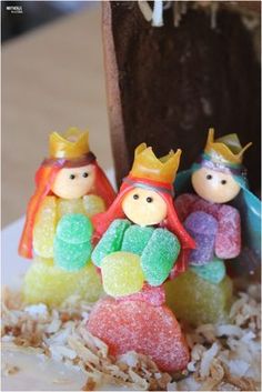 three small toy figurines sitting on top of a pile of rice krispy treats