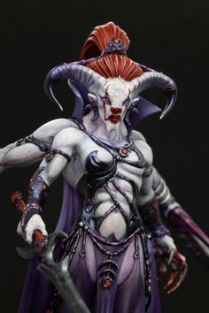 a statue of a female demon with red hair and horns